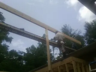 Carpenter setting a ridge beam over a new addition frame — Ice Dam Removal by Roofing Brothers in Minturn